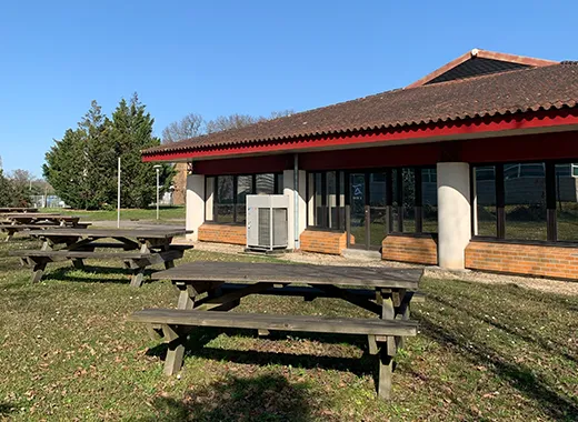 Parc arboré aménagé avec parking et un bâtiment